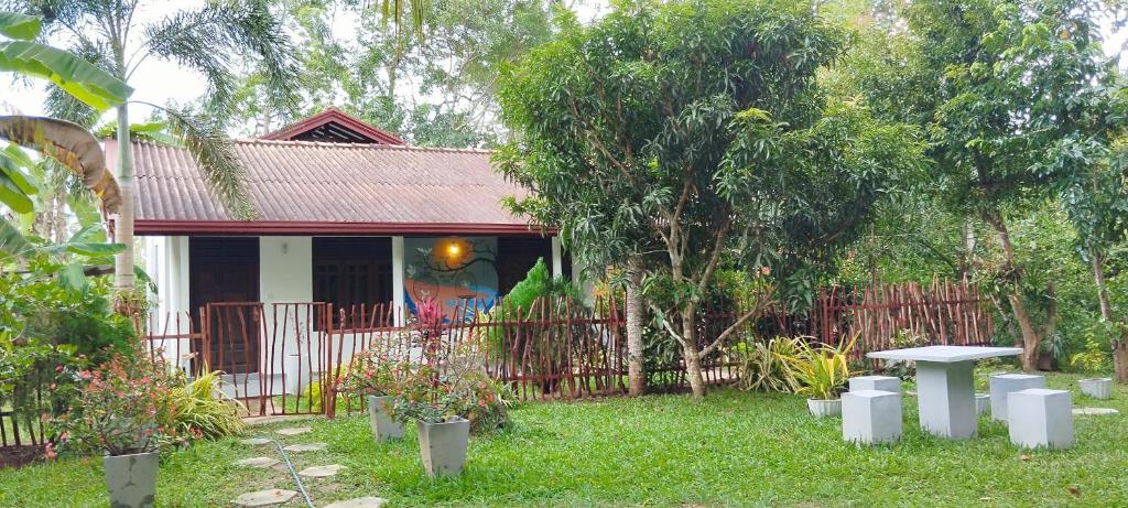 a house with a fence and a table in the yard at Eco nest marakolliya in Tangalle
