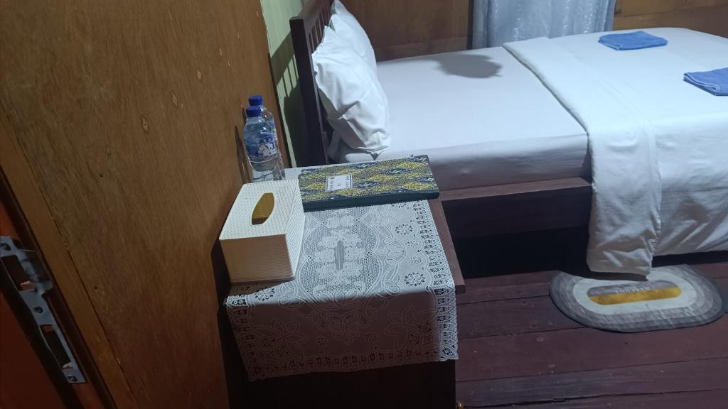 a bottle of water sitting on a box next to a bed at Watuburu Cottage & Restaurant in Kelimutu