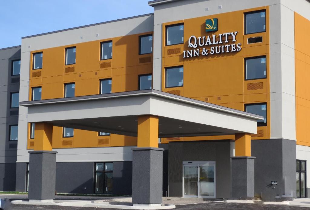 un edificio de oficinas con la posada theania y las suites firman en él en Quality Inn & Suites Kingston en Kingston