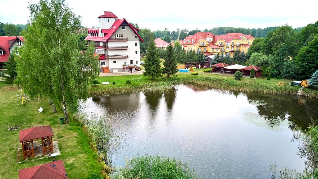 Aerial view of pond framed by hotel buildings, grassy grounds, gazebos, and surrounding trees.