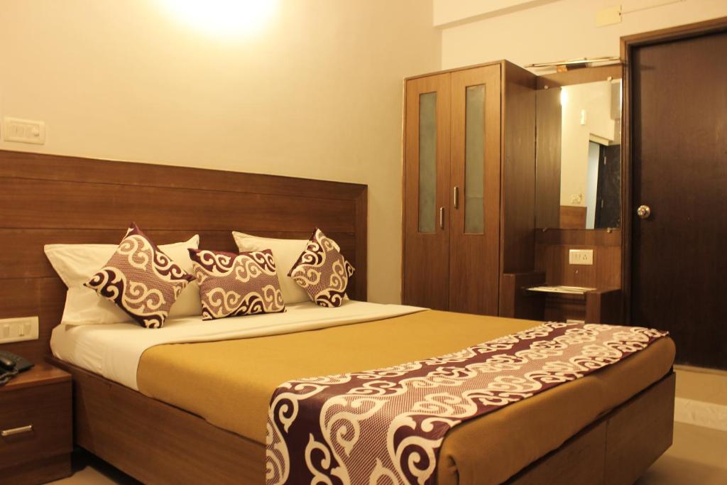 a bedroom with a large bed with a wooden headboard at Mount Residency in Chennai
