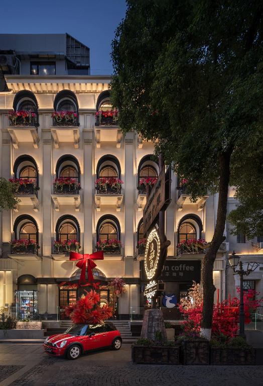 a red car parked in front of a building at 龄舍1927酒店 in Wuhan