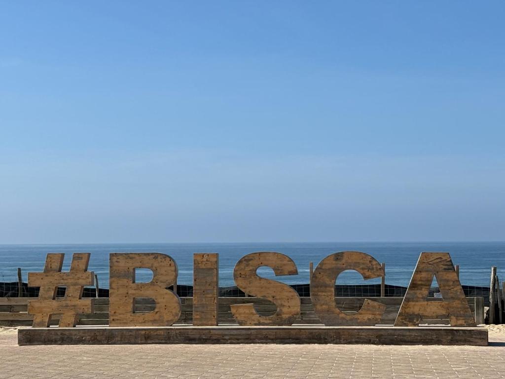 un panneau indiquant la plage avec l'océan en arrière-plan dans l'établissement T2 Boho près du lac, à Biscarrosse