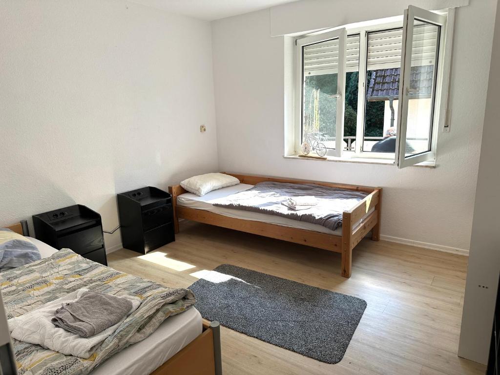 ein Schlafzimmer mit zwei Betten und einem Fenster in der Unterkunft Großes 2-Zimmer Apartment mit TV, Wifi in Oerlinghausen