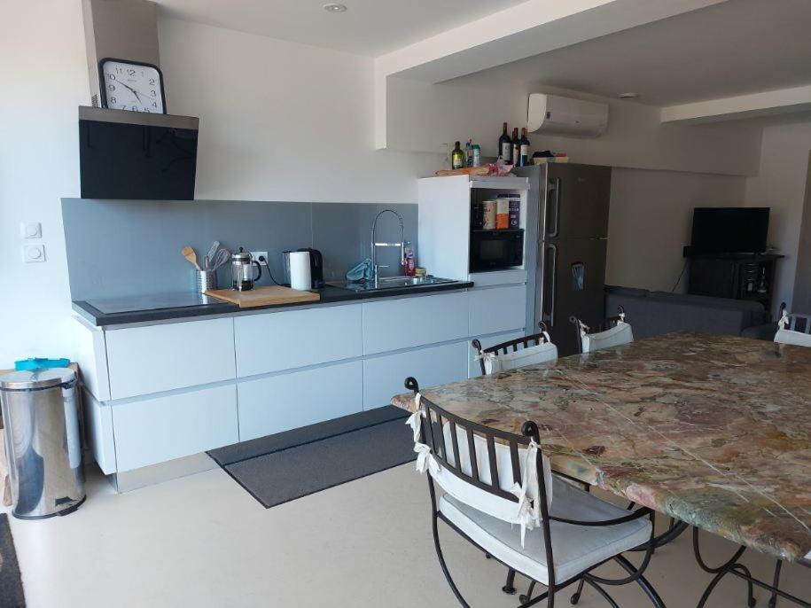 - une cuisine avec une table, des chaises et un comptoir dans l'établissement le logis du truqué, à Lège-Cap-Ferret