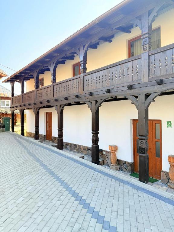 a building with a porch and a walkway at Gospodaria Klaus in Rozavlea