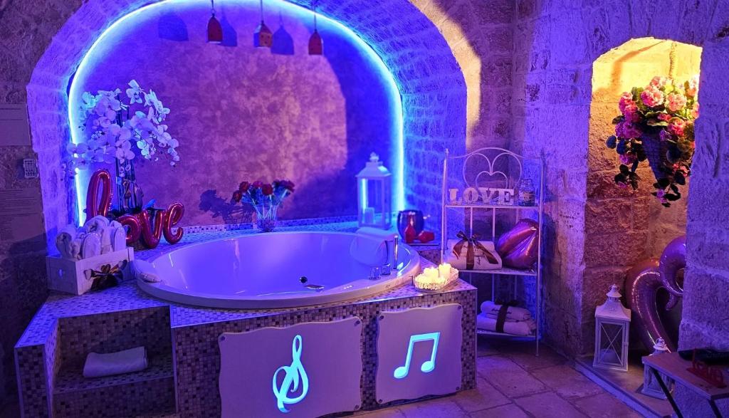 Fioletowa łazienka z wanną z oświetleniem w obiekcie SINFONIE PUGLIESI LUXURY ROOM w mieście Turi