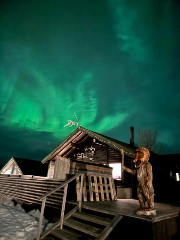 a statue of a man standing on top of a house at Big cabin in Lyngen Fjords in Jægervatnet