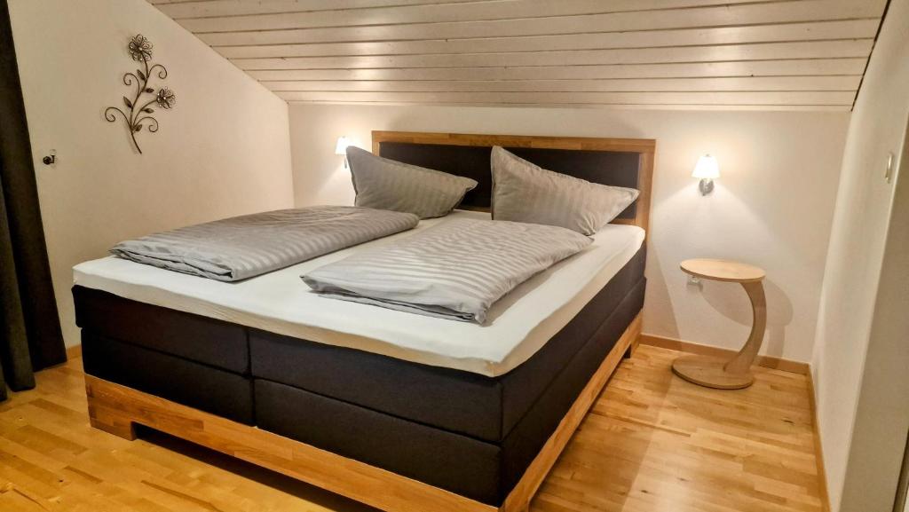 Cama grande en habitación con cabecero de madera en Ferienwohnung Edelweiß, en Bolsterlang