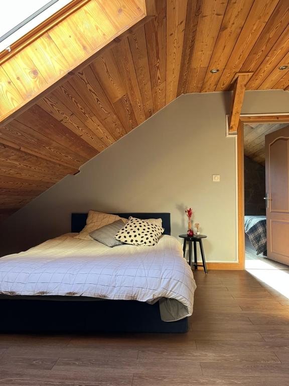 une chambre avec un lit avec un plafond en bois dans l'établissement Appartement en face des remontées mécaniques, à Briançon