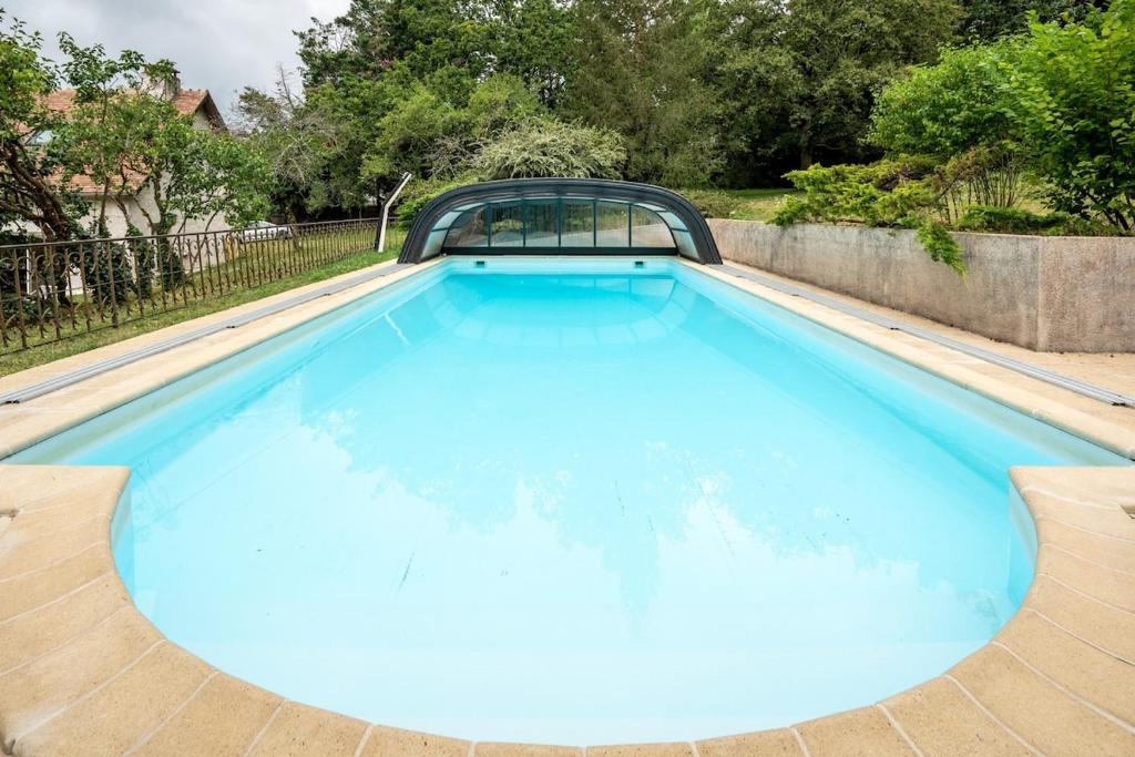 a large pool with blue water in a backyard at Le Clos des Moriers 2 hours from Paris-Piscine-12 pers in Blois