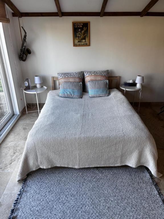 - une chambre avec un grand lit et 2 tables dans l'établissement Studio Avec jardin privé, à Bergerac