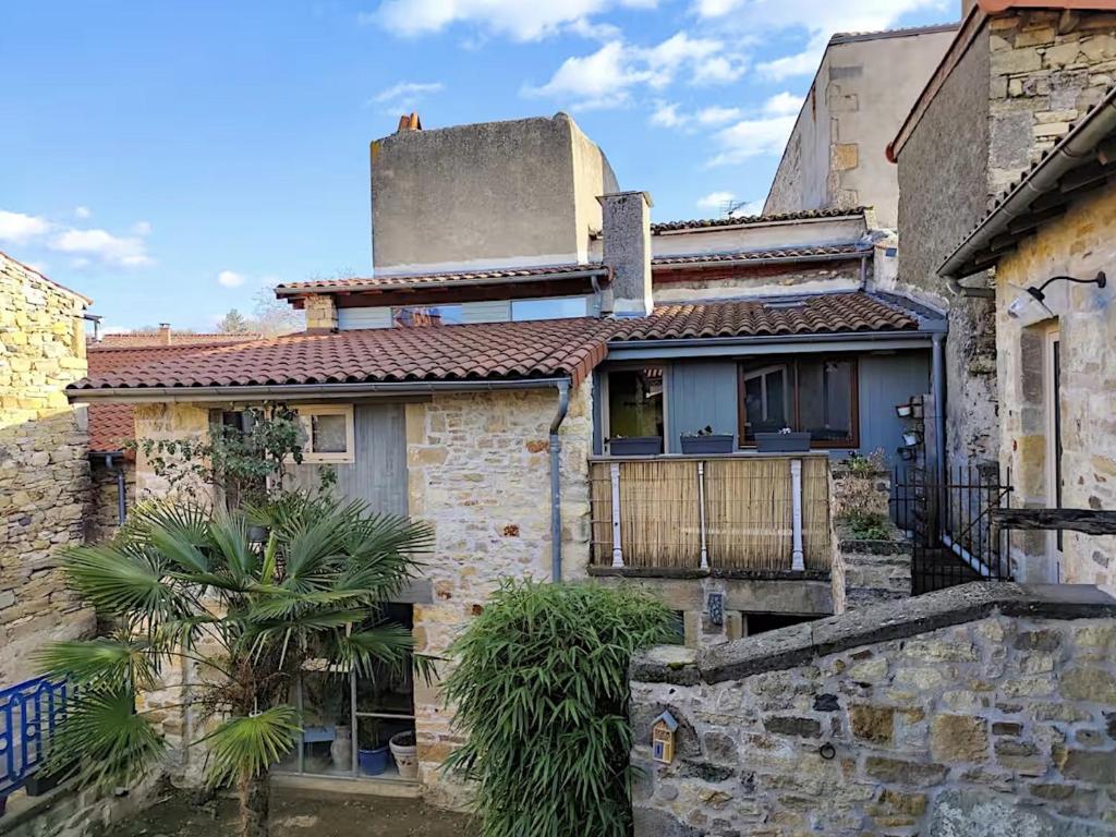 an old stone house with a tree in front of it at Chez Mathilde et Kévin in Saint-Maurice