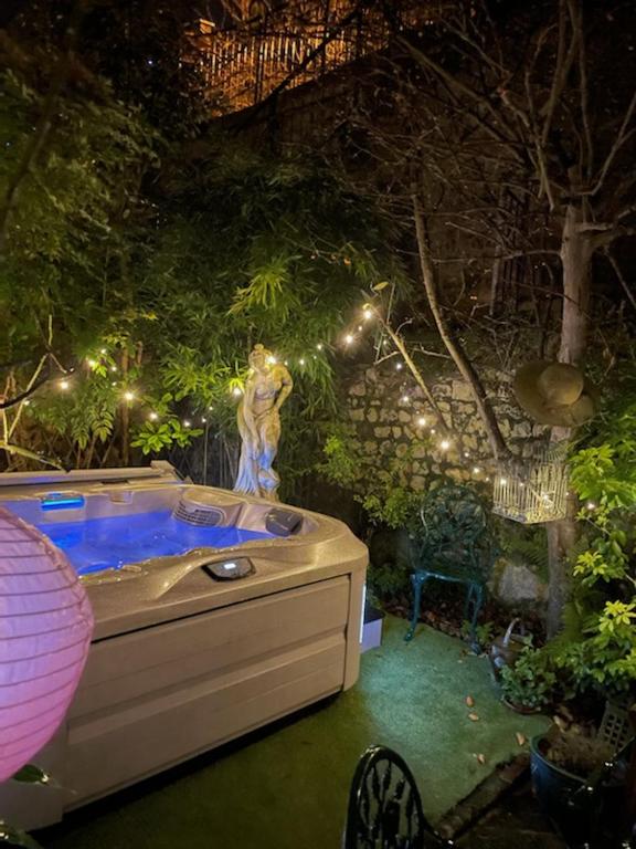 a jacuzzi tub in a garden at night at chambres d'hotes le nid du phare avec option jacuzzi privé in Honfleur
