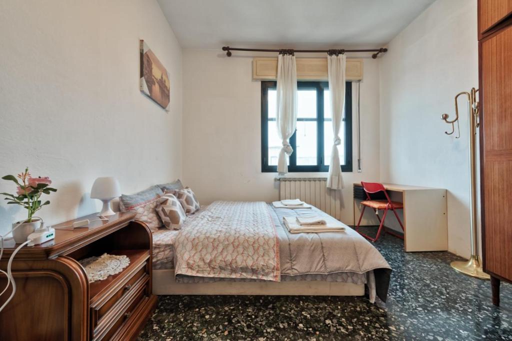 a bedroom with a bed and a desk and a window at Easy Old City Apt Venice in Venice
