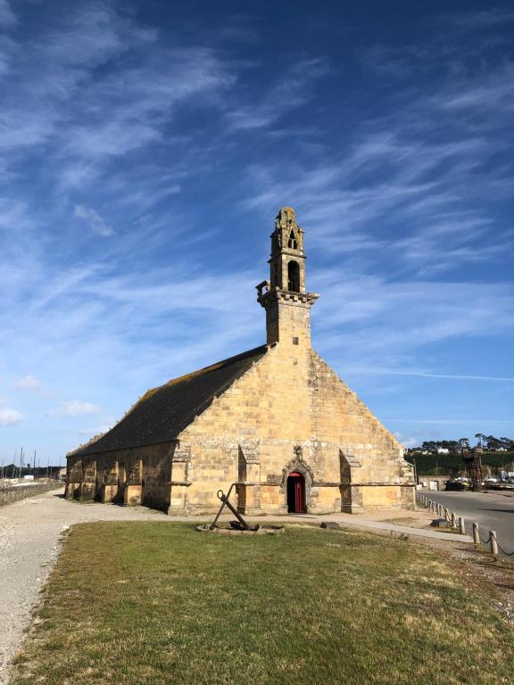 une ancienne église en pierre avec une tour sur l'herbe dans l'établissement Gwenlan, à Dinard