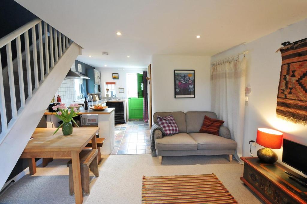 una sala de estar con un sofá y una mesa en Y Cwtch Newport Pembrokeshire, en Newport