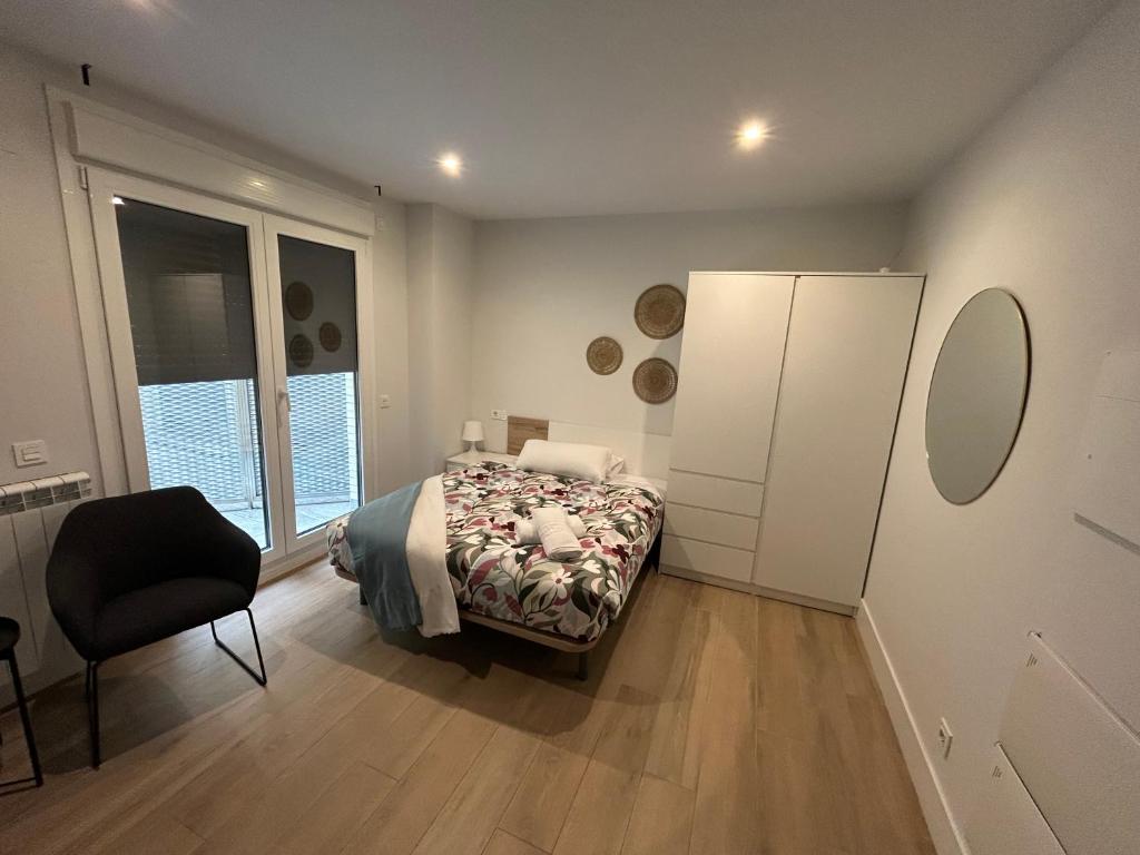 a bedroom with a bed and a chair in it at Apartamentos Dream in Salamanca
