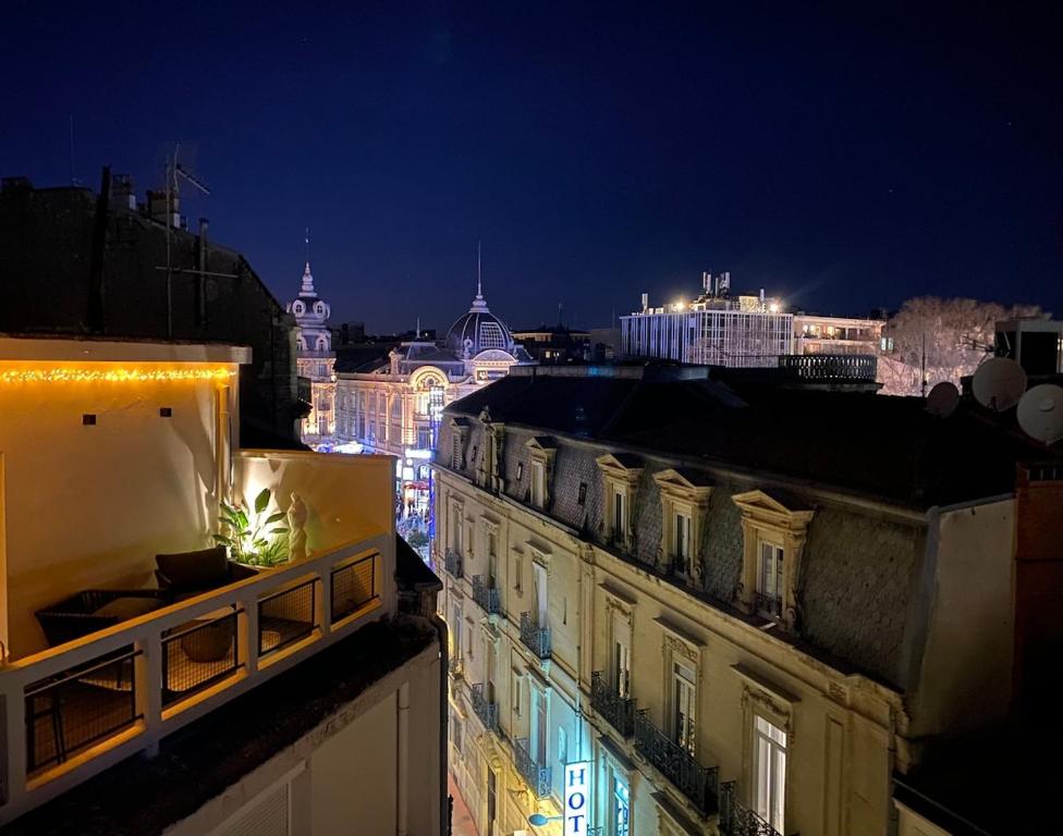 une vue d'une ville la nuit avec des lumières dans l'établissement Stardust Comédie - Élégant Confort & Terrasse, à Montpellier