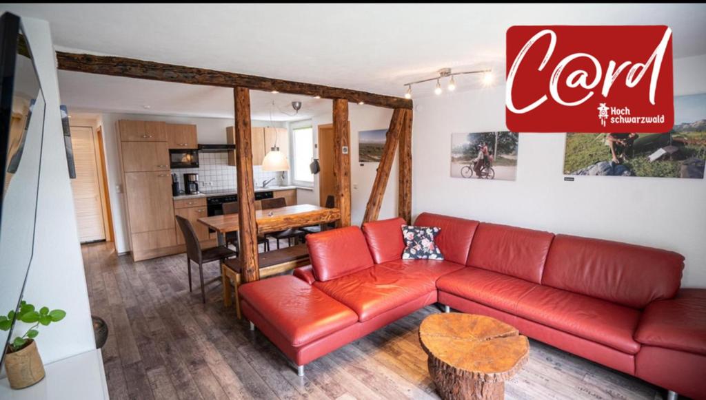 a living room with a red couch and a table at Ferienwohnung Radhaus, Todtnau, 3 Schlafzimmer in Todtnau
