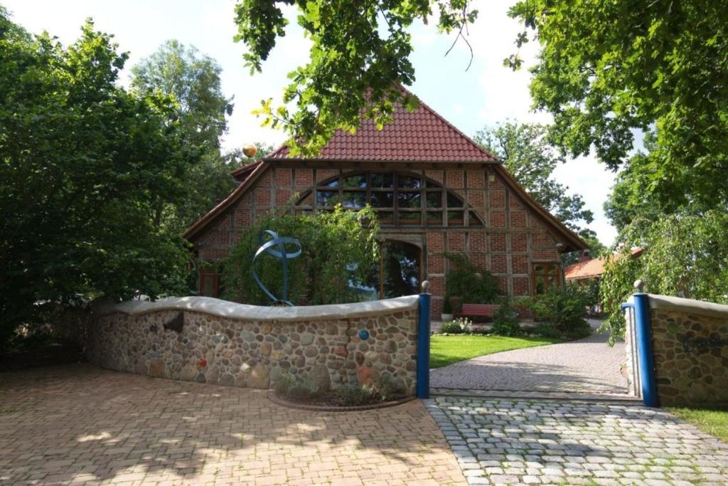 un edificio in mattoni con un muro di pietra di fronte di Urlaubsnest Das Künstlerrefugium a Bleckede