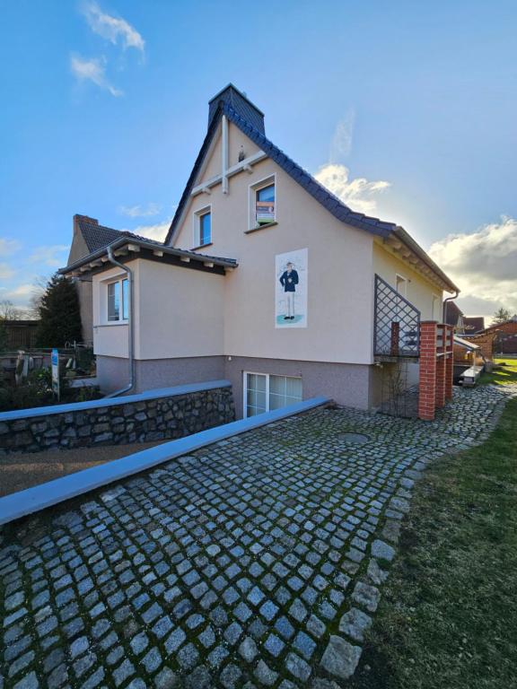 ein Haus mit einer gepflasterten Einfahrt davor in der Unterkunft Kapitänshaus - Zickenstube in Barth