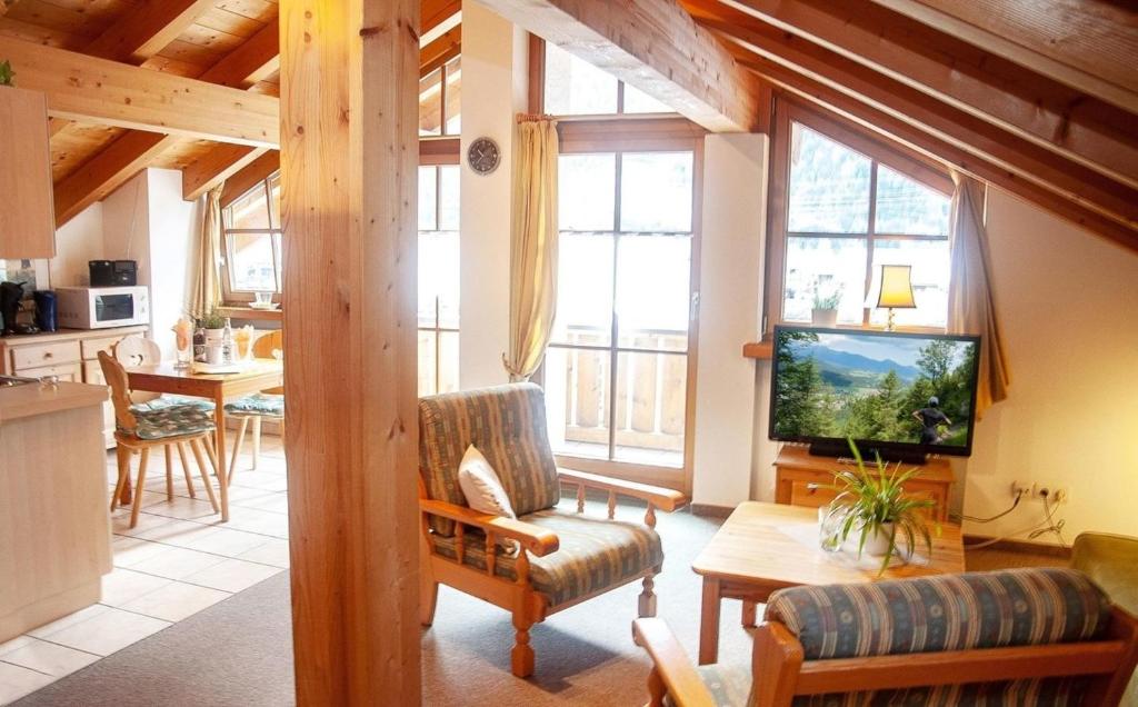 a living room with a couch and a tv and some windows at Gänseblümchen -805- in Mittenwald