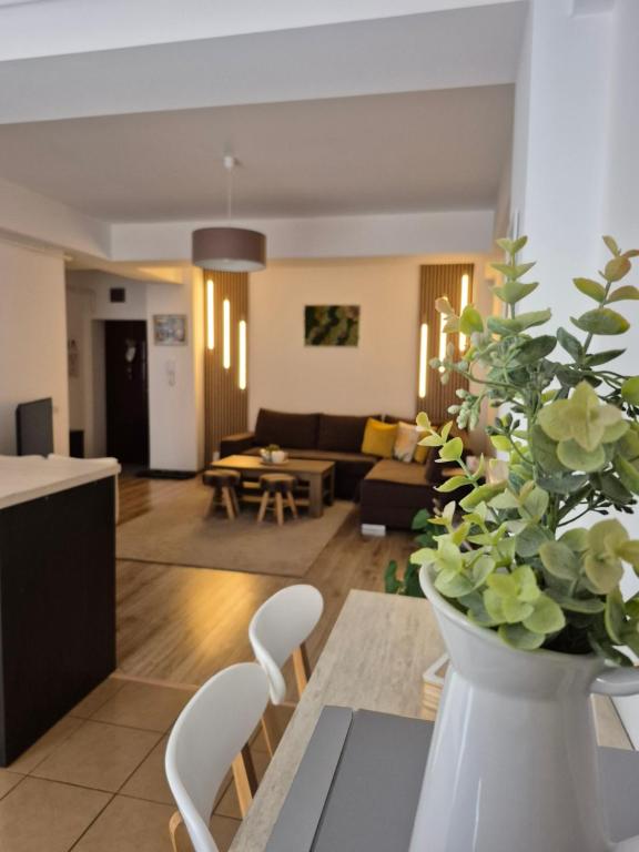 ein Wohnzimmer mit einer Vase mit Blumen auf einem Tisch in der Unterkunft Angel apartament in Sibiu