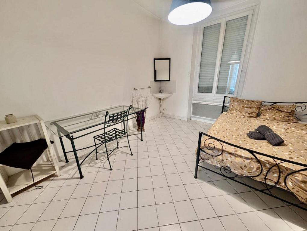 une chambre avec deux lits et une table dans l'établissement Bright & Spacious 2-Bedroom Apartment - Parking & Close to Train Station & Downtown, à Grenoble