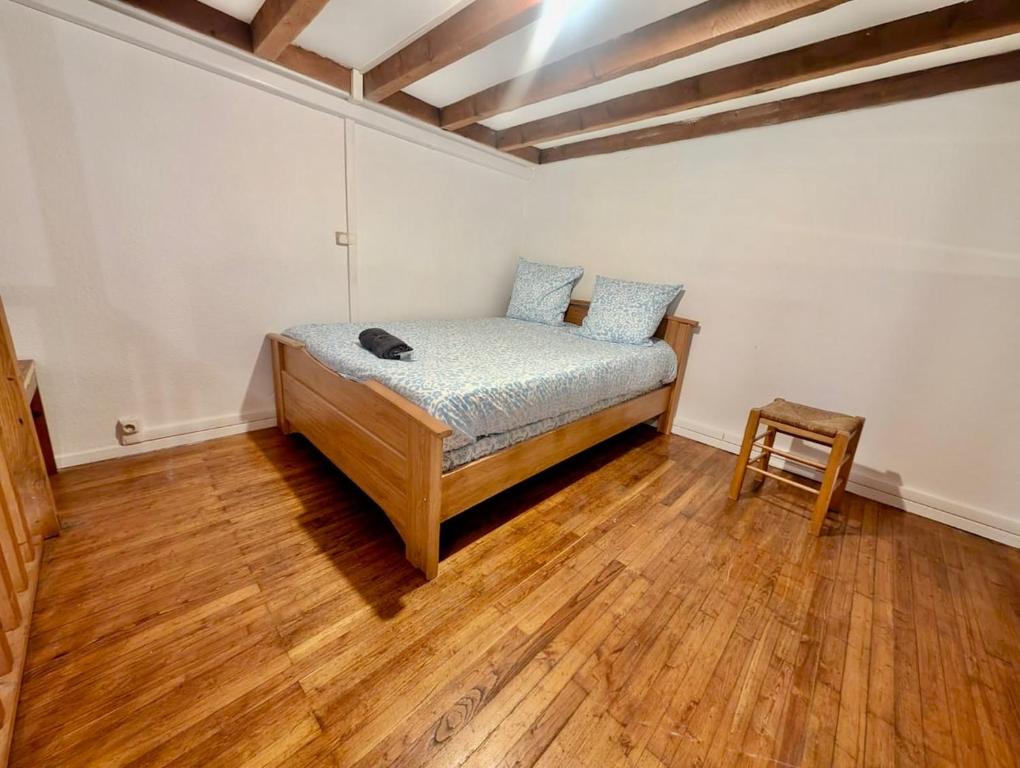 une chambre avec un lit et une chaise dedans dans l'établissement Cozy Studio in Championnet - Quiet & Central Location, à Grenoble