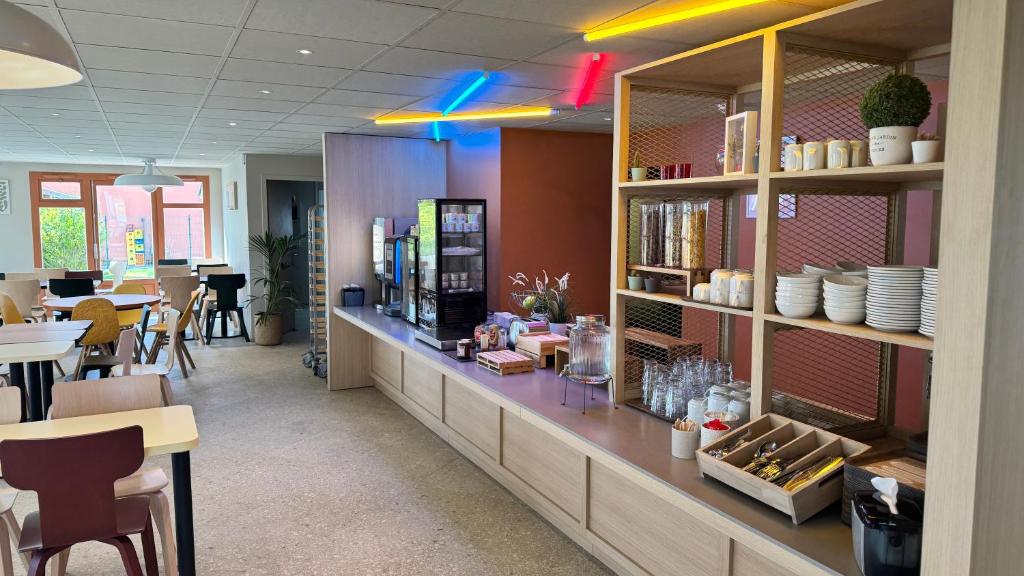 un restaurant avec un comptoir avec des plats dessus dans l'établissement B&B HOTEL Saint-Witz Roissy, à Saint-Witz