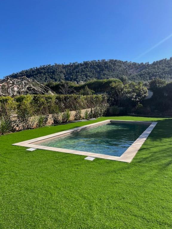 - une piscine au milieu d'une pelouse dans l'établissement Maison provençale de Plain pied avecGrand jardin et Piscine, à Aubagne