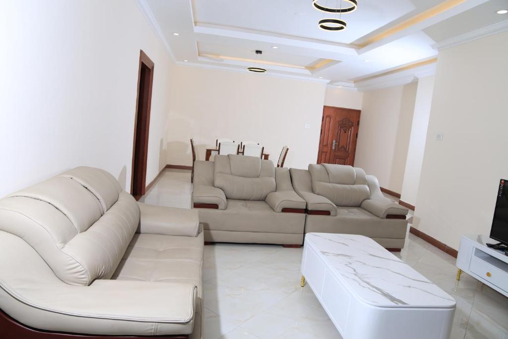 a living room with white couches and a tv at My dream apartment in Addis Ababa
