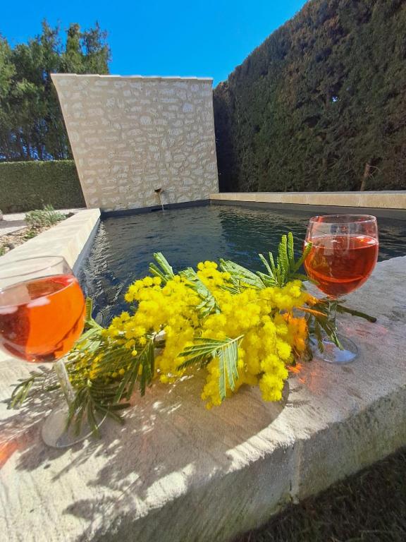 deux verres à vin et un bouquet de fleurs sur une table dans l'établissement La maison de Manon, 4-5personnes, 75m2, centre village avec piscine privée, à Maussane-les-Alpilles