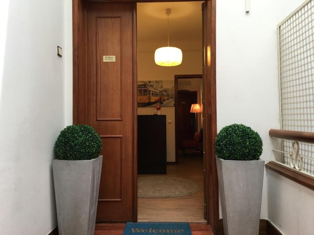 a hallway with two potted plants next to a door at Guest House Guerra Junqueiro in Lisbon