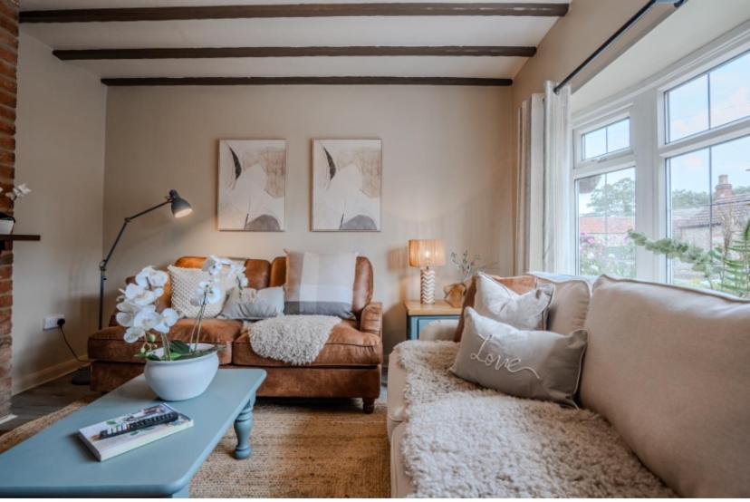 un salon avec un canapé et une table dans l'établissement Jasmine Cottage, à Skipsea