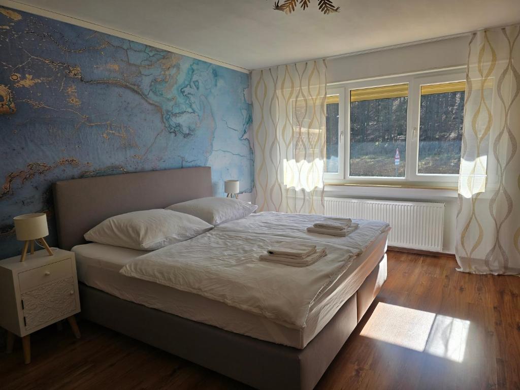 a bedroom with a large bed with a blue wall at Marburg Apartment feuriger Felix mit Kamin und Garten in ruhiger Waldrandlage in Marburg an der Lahn