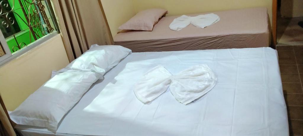 a bed with white sheets and bow ties on it at Casa formosa in Porto Seguro