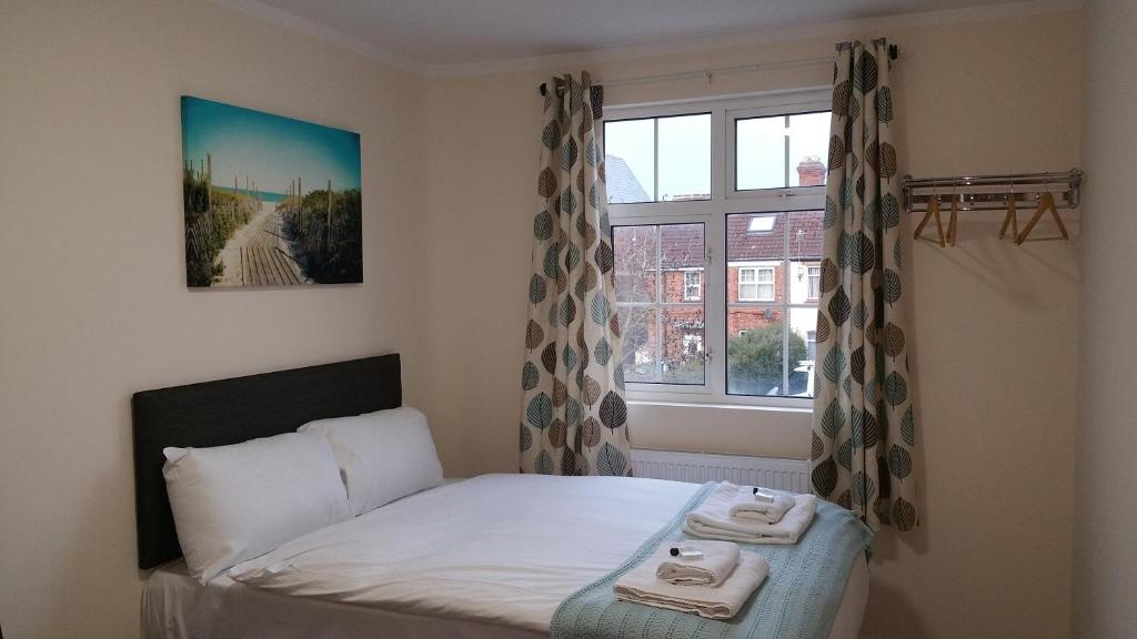 a bedroom with a bed and a window with towels at The Oxford House in Oxford