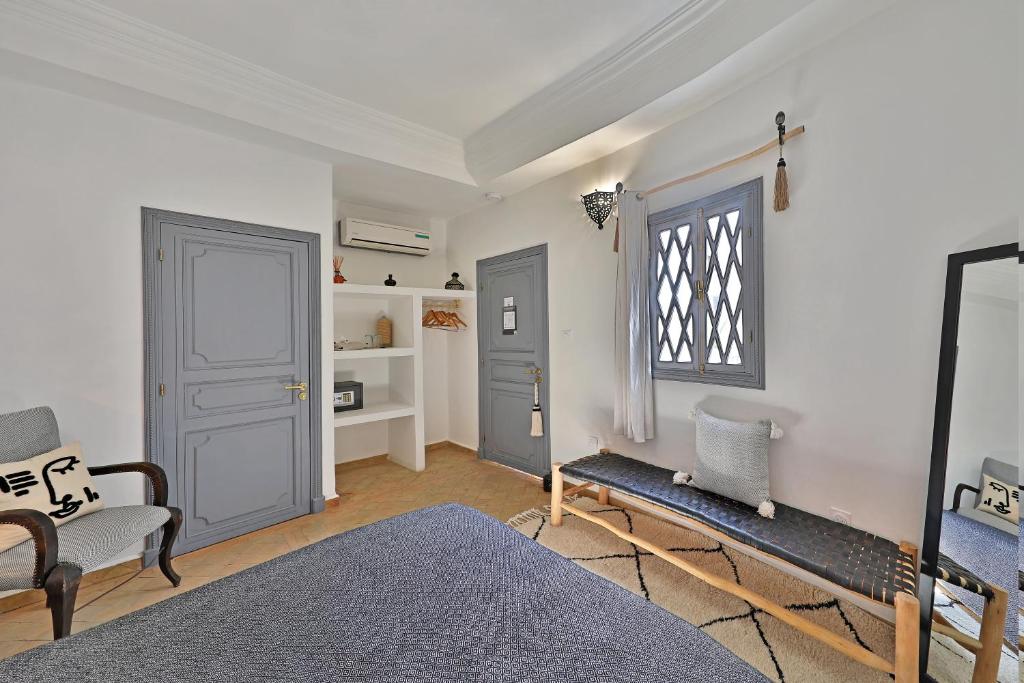 Cette chambre dispose d'une porte, d'une chaise et d'une fenêtre. dans l'établissement Riad Amya & Spa, à Marrakech