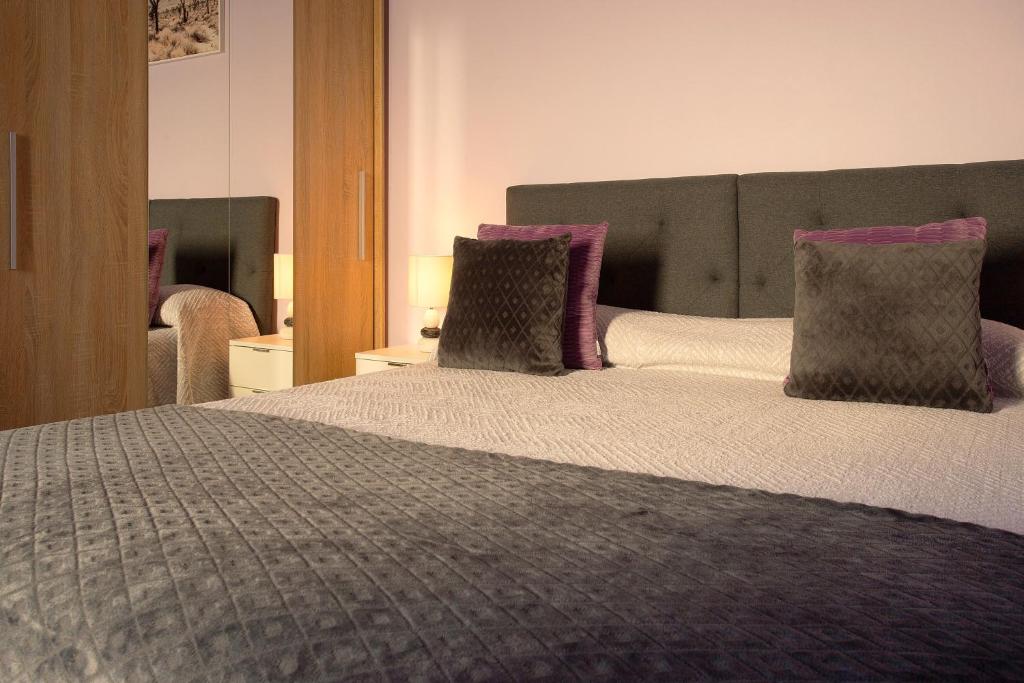 a bedroom with a large bed with purple pillows at Village Center One Bedroom Apartment in Porto Moniz