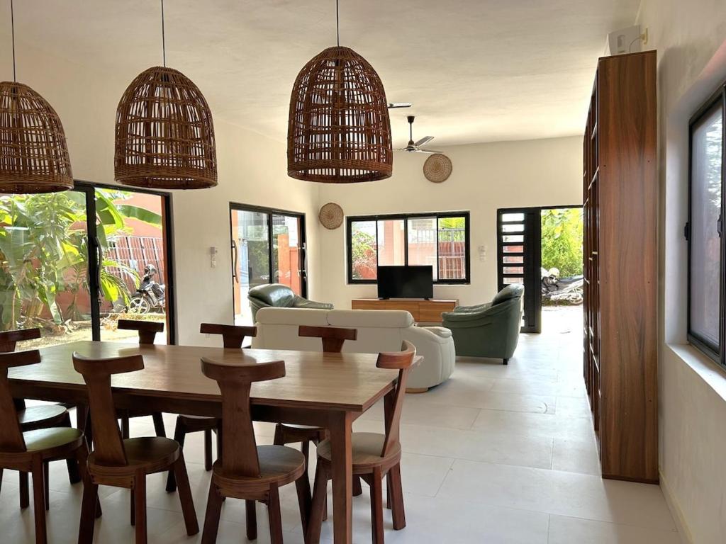 a living room with a wooden table and chairs at Quiet Villa Near Sea, Cotonou in Sèmè-Podji