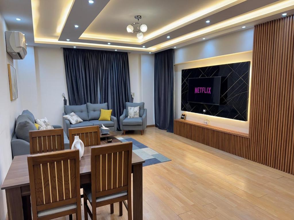 a living room with a table and a tv at Rehab Modern Apartment in New cairo