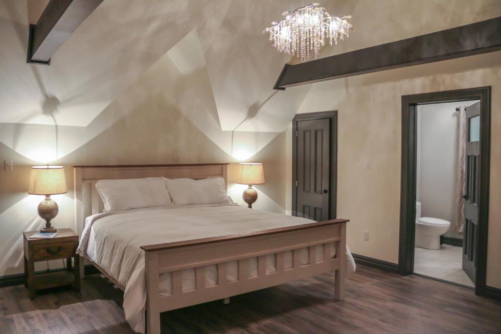 a bedroom with a large bed and a chandelier at Russelltown Inn in Bonavista