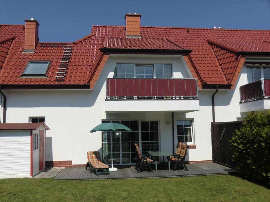 a house with a balcony with a table and chairs at Ferienwohnung Sünnenkringel 58 in Zingst