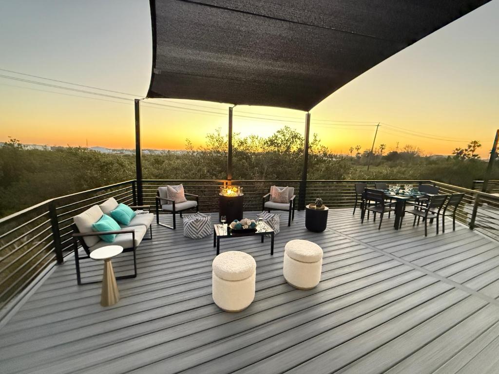 a deck with a table and chairs and a sunset at Modern Sanctuary in Saint Augustine in St. Augustine