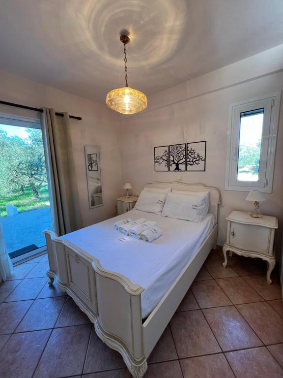 ein Schlafzimmer mit einem Bett und einem Kronleuchter in der Unterkunft Olive Tree House I in Dhermatiánika