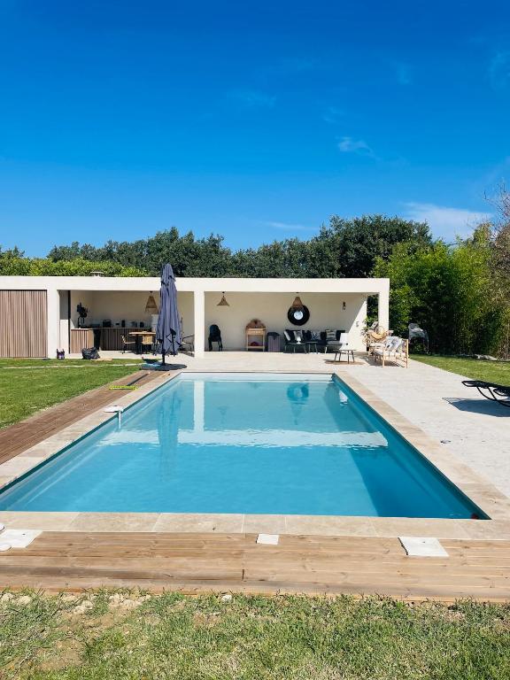 une piscine devant une maison dans l'établissement Villa avec Pool House au cœur des vignes - Lubéron, à La Tour-dʼAigues