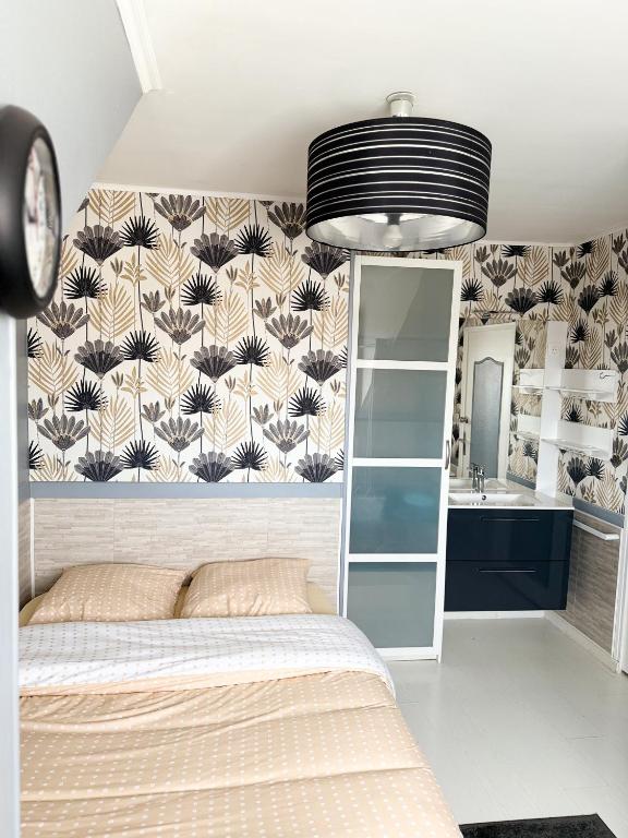 - une chambre avec un lit et un papier peint fleuri dans l'établissement Les clés angevines Chambre numéro 7, à Angers