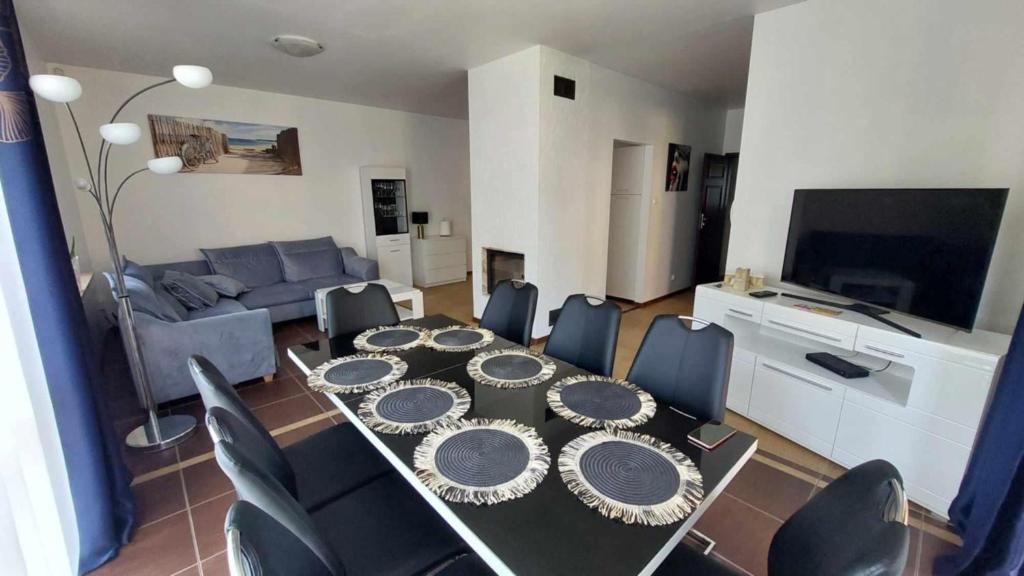 Una mesa de comedor y sillas en una sala de estar. en Park Miedzywodzie, en Międzywodzie